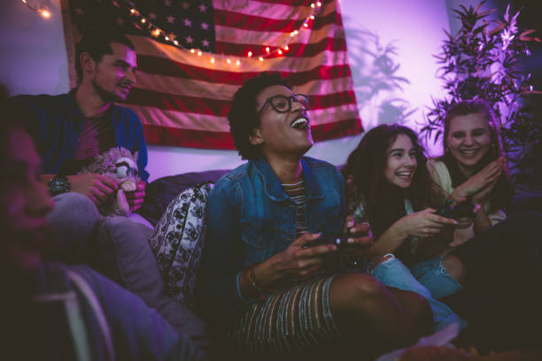 Young multi-ethnic friends relaxing at home and playing video games Happy multi-ethnic teenage friends hanging out at home together and playing video games college dorm party stock pictures, royalty-free photos & images