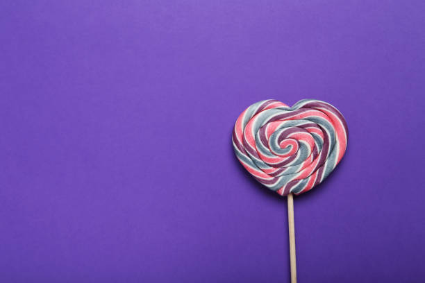 Sweet lollipop on purple background