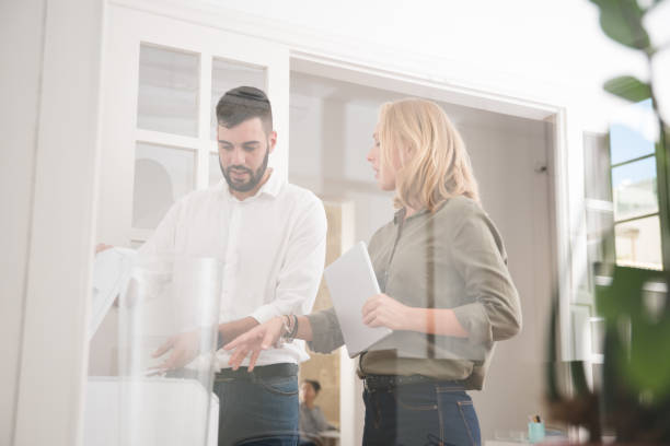istock Business colleagues standing around the copier 1001422282