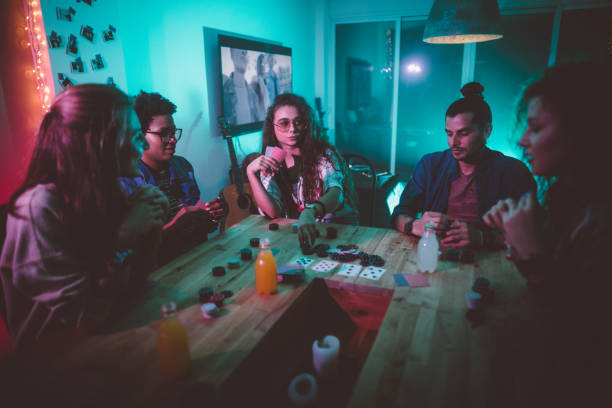 Multi-ethnic hipster friends playing poker at home
