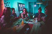 istock Multi-ethnic hipster friends playing poker at home 1001422556