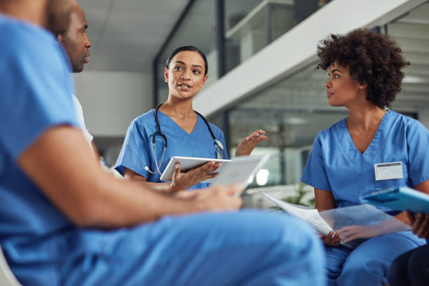 Deciding on a course of treatment for their patients Shot of a group of medical practitioners having a discussion in a hospital nurse stock pictures, royalty-free photos & images