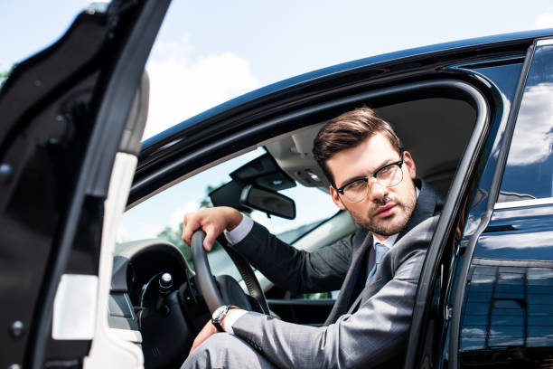istock pensive businessman in eyeglasses looking away while sitting in car 1001426912