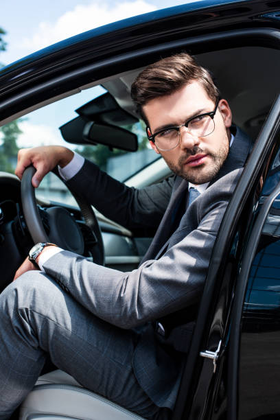 istock pensive businessman in eyeglasses looking away while sitting in car 1001426934