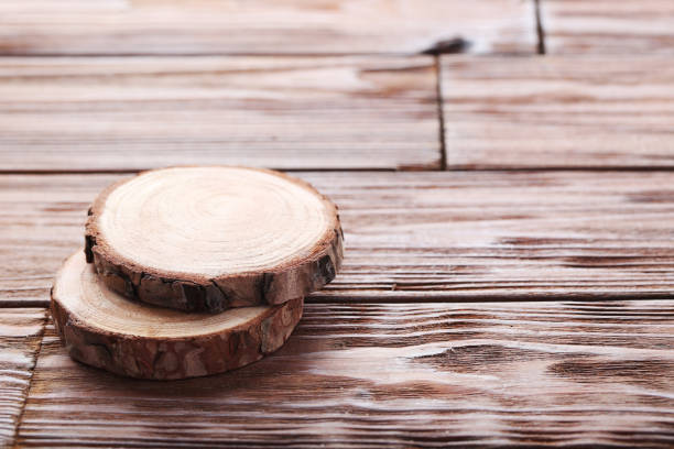 istock Cross section of tree trunk on wooden table 1001430414