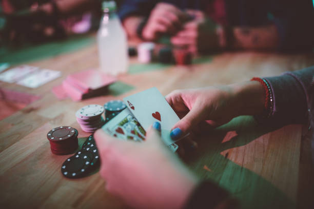 Woman playing blackjack and holding cards at table Close-up of woman's hands playing poker and holding cards while relaxing with friends at home child gambling chip gambling poker stock pictures, royalty-free photos & images