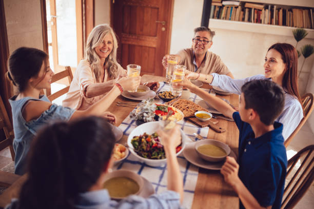 istock Happy multi-generation family toasting during family lunch in rustic cottage 1001431014