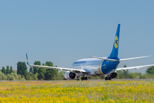 The airplane of the Ukraine International Airlines is taking off at the Boryspil airport on a sunny summer day. Ukraine International Airlines airplane accelerated down the runway for takeoff, Boryspil, Ukraine. Ukraine International Airlines PJSC (UIA) is the flag carrier and the largest airline of Ukraine, with its head office in Kiev and with its main hub at Boryspil International Airport outside Kiev operating domestic and international passenger flights and cargo services.