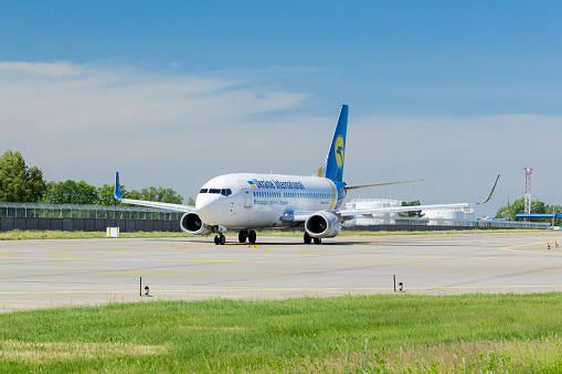 Ukraine International Airlines aircraft is taxiing to take off at the Boryspil airport on a summer day. Ukraine International Airlines PJSC (UIA) is the flag carrier and the largest airline of Ukraine, with its head office in Kiev and with its main hub at Boryspil International Airport outside Kiev operating domestic and international passenger flights and cargo services.