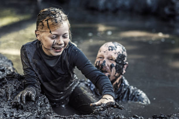 istock Father and daughter having sporty fun at a public mud run obstacle course 1001434096