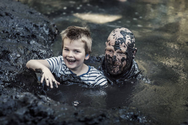 istock Father and son having sporty fun at a public mud run obstacle course 1001434218