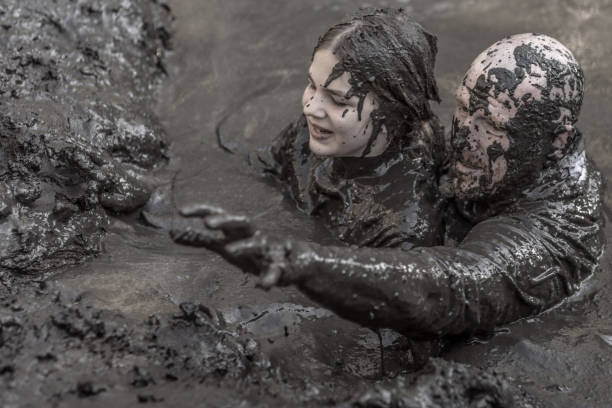 istock Father and daughter having sporty fun at a public mud run obstacle course 1001434332