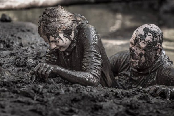 istock Father and daughter having sporty fun at a public mud run obstacle course 1001434364