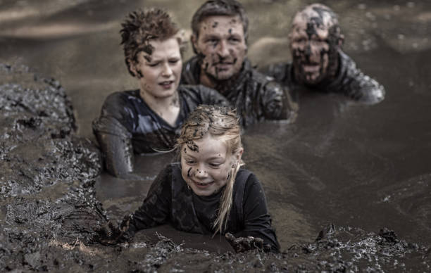 istock Family having sporty fun at a public mud run obstacle course 1001434516