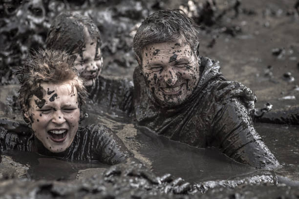 istock Family having sporty fun at a public mud run obstacle course 1001434678