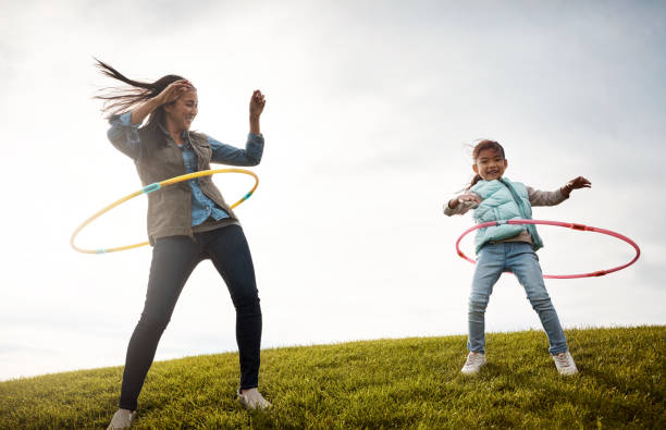 Niña con hula hoop en el brazo en un parque Fotografía de stock - Alamy