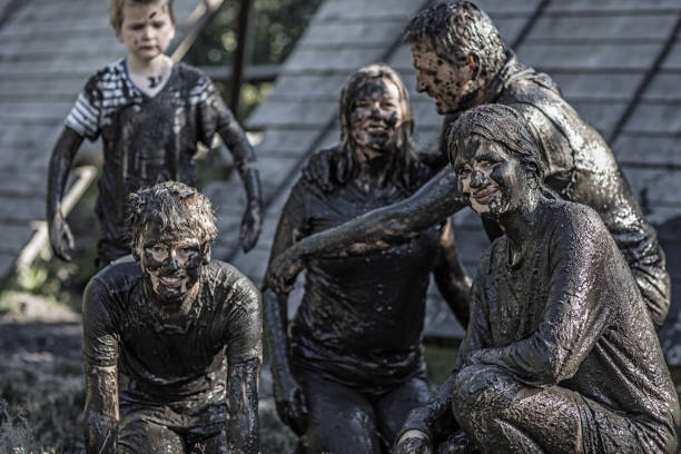 istock Family having sporty fun at a public mud run obstacle course 1001435020