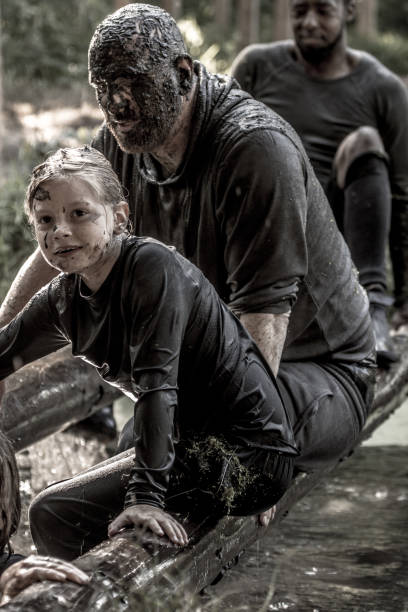 istock Family having sporty fun at a public mud run obstacle course 1001437588