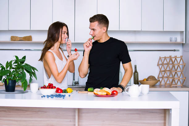 istock cute young woman and man in white kitchen 1001437706