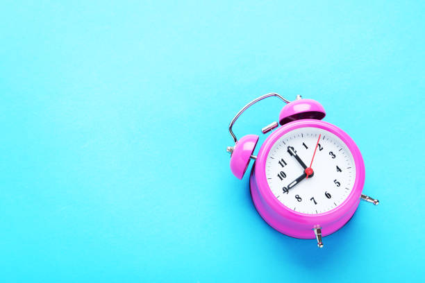 istock Pink alarm clock on the mint background 1001437724