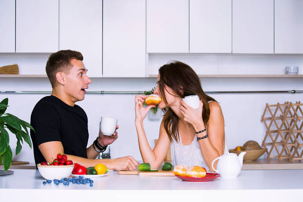 istock cute young woman and man in white kitchen 1001438340
