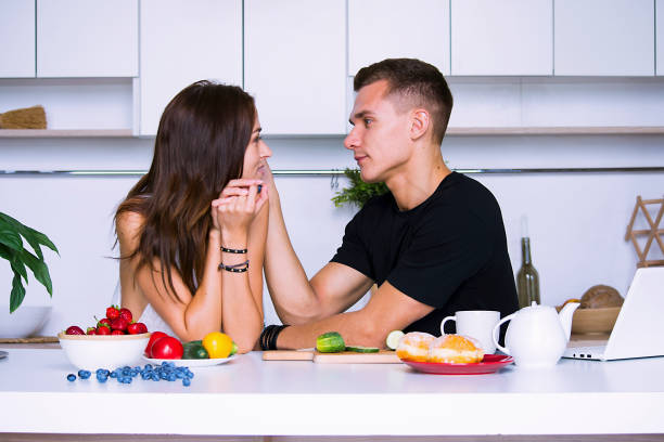 istock cute young woman and man in white kitchen 1001441554