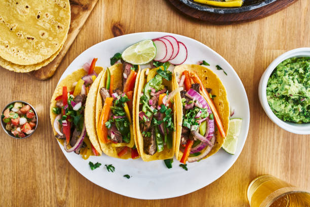 tasty mexican tacos with beef fajita filling served with salsa tasty mexican tacos with beef fajita filling served with salsa and guacamole in flat lay composition fajita photos stock pictures, royalty-free photos & images