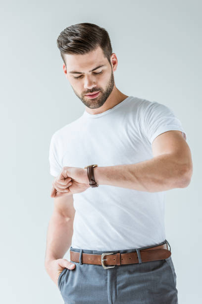 istock Fashionable confident man checking his watch isolated on white background 1001473462