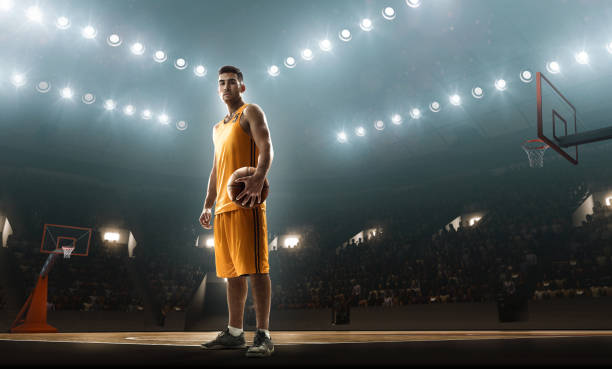 istock Basketball player on big professional arena holding a ball 1001483274