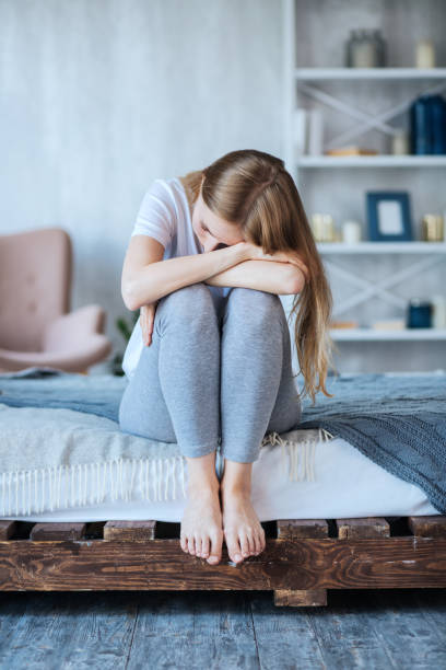 istock Unhappy woman sitting on the couch 1001486884