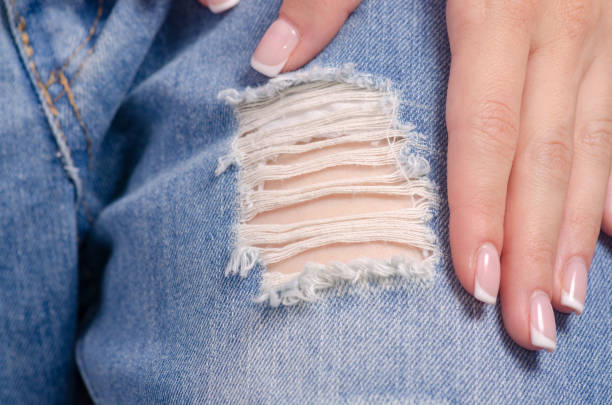 istock Woman in torn blue jeans macro fashion 1001490954