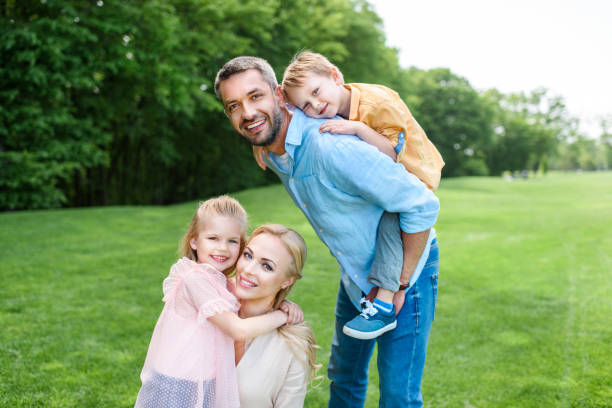 istock happy family with two kids smiling at camera while spending time together in park 1001502398