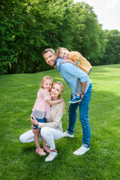 istock happy family smiling at camera while spending time together in park 1001502842