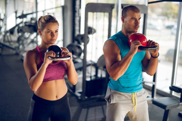 istock Two young athletic people doing kettlebell exercises at gym 1001505682