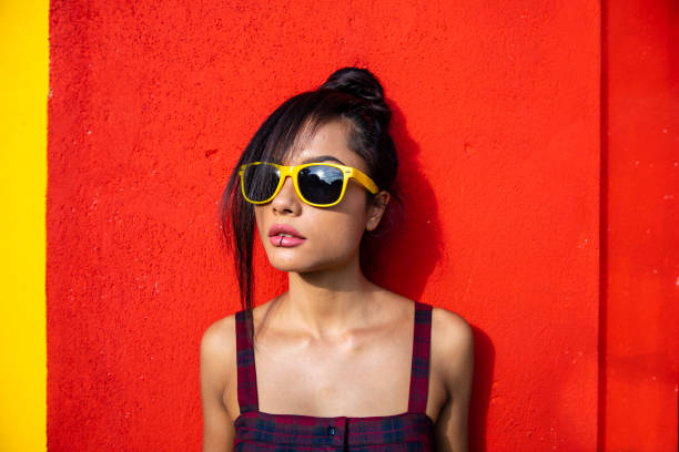 Beautiful young woman standing in front of red background.