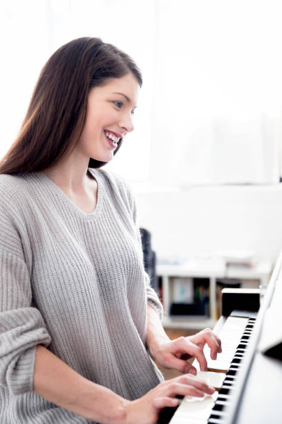 istock Beautiful Girl Playing Piano 1001509422
