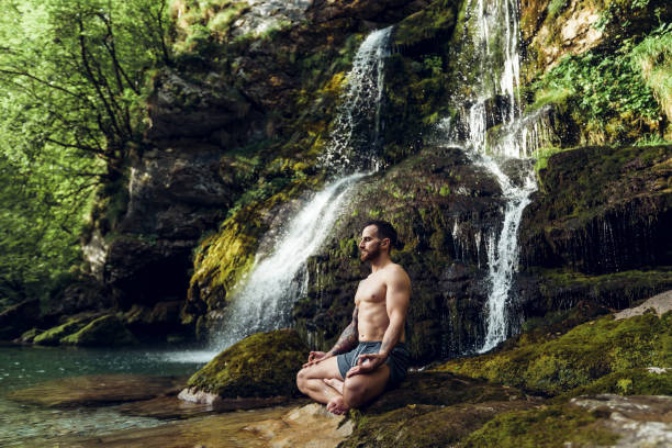Yoga Man practicing yoga in nature man yoga tattoo stock pictures, royalty-free photos & images