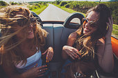 Hipster girl friends enjoys a summer road trip