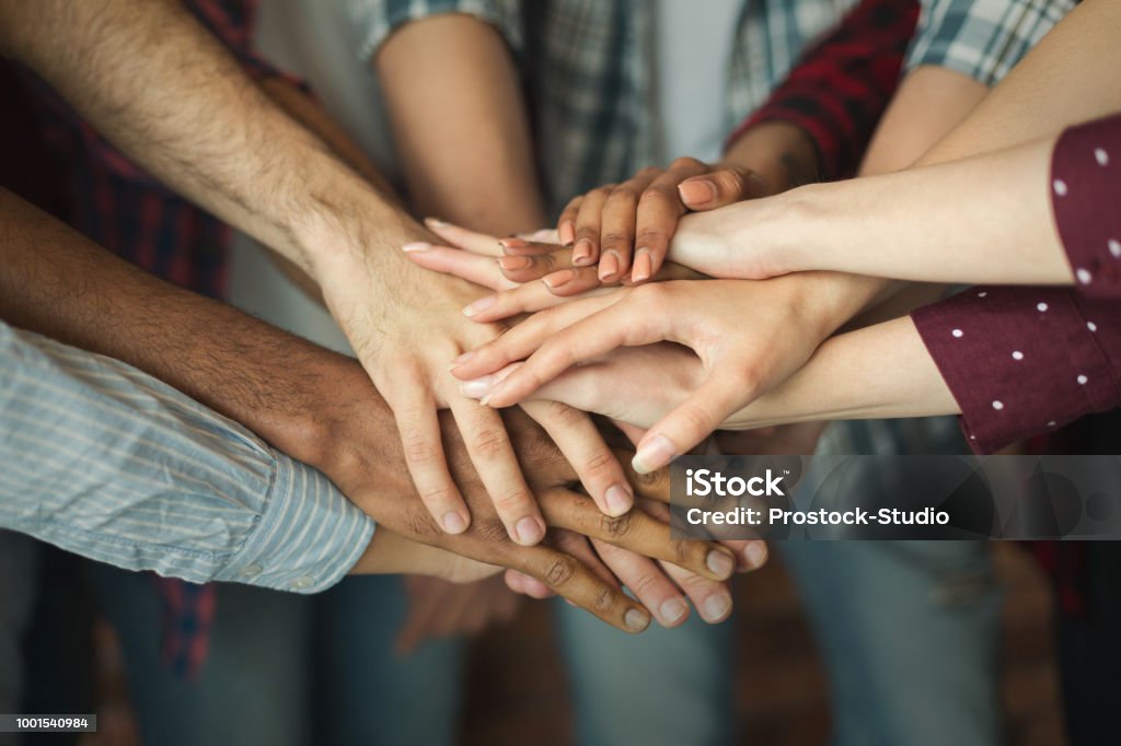 Group of friends holding hands together Friendship and teamwork. Multiethnic company of friends stacked hands together, copy space Hand Stock Photo