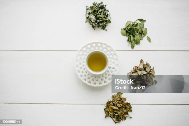 Fresh Fragrant And Healthy Herbal Tea In A Glass Or Mug On A White Wooden Surface Next To It Lie Various Dried Herbs For Making Tea Healthy Product Stock Photo - Download Image Now