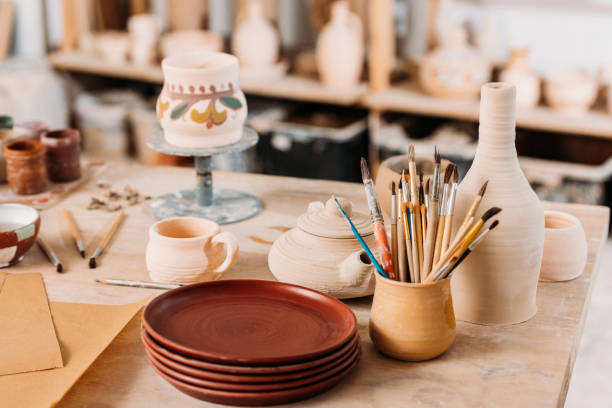 istock ceramic dishware and brushes on wooden table in pottery workshop 1001562816