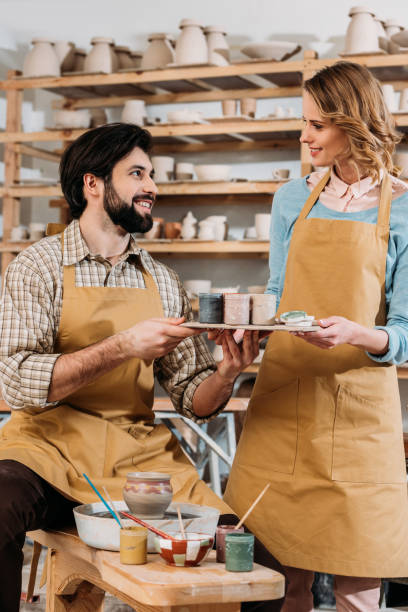 istock couple in aprons with paints in pottery workshop 1001563138