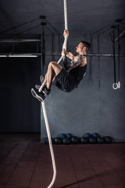 istock Athlete doing rope climb at gym 1001563964