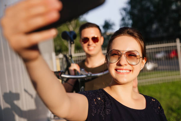 istock Funny girl takes a selfie with a guy on mobile device 1001566462
