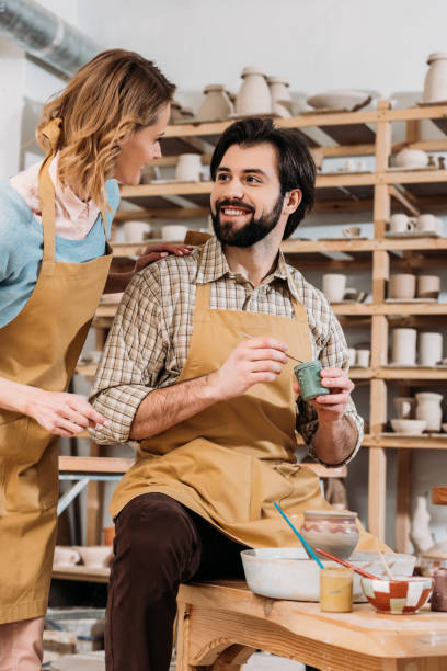 istock female potter teaching man how to paint ceramics in workshop 1001567854