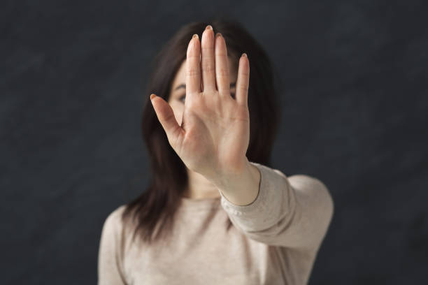 junge frau zeigt stop schild - zurückweisung stock-fotos und bilder