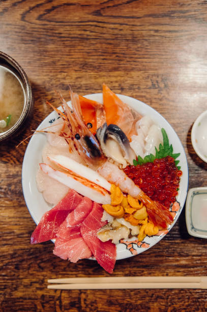 istock Kaisendon Japanese sashimi rice bowl on wood table top view shot 1001571024