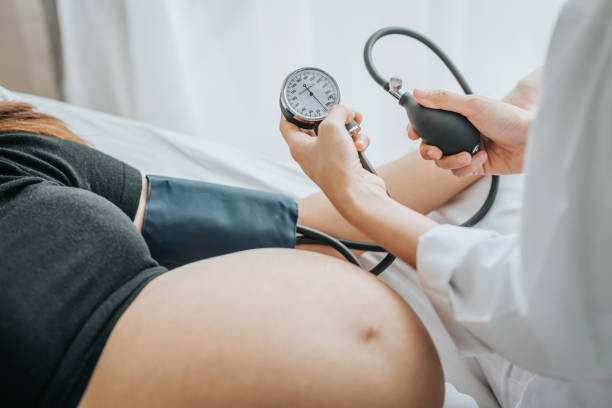 comprobar la presión arterial de una mujer embarazada el doctor - hipertension fotografías e imágenes de stock