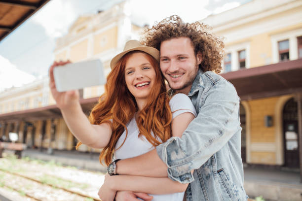 istock Happy young couple using mobile phone to take a selfie 1001571252
