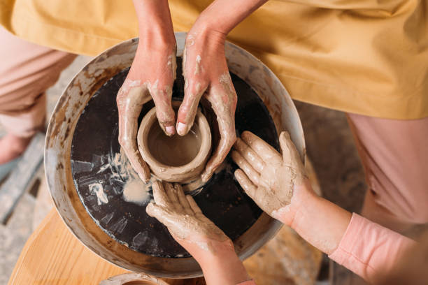 istock top view of teacher and kid making ceramic pot on pottery wheel 1001575446